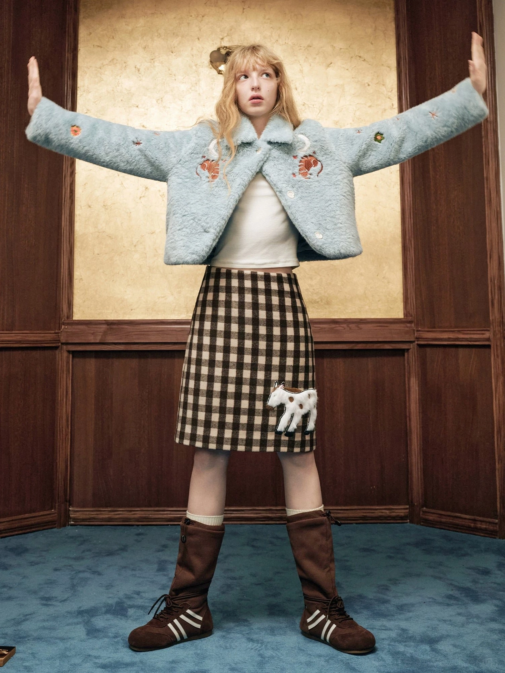 Brown gingham pony appliqué wool blend mini skirt with a light blue cropped fuzzy jacket in a vintage interior setting