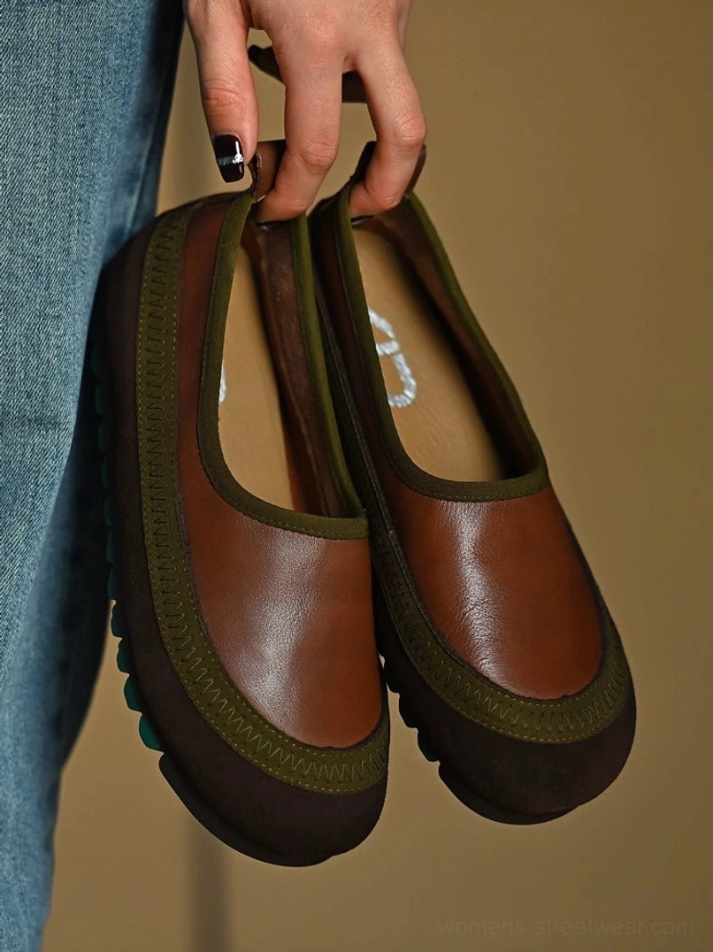 Brown and olive green leather slip-on shoes displayed over blue denim, featuring a smooth cowhide upper and textured green traction outsole