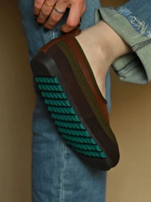 Brown green casual leather slip-on shoe worn with rolled frayed jeans, showing the 3cm hidden lift and green anti-slip outsole