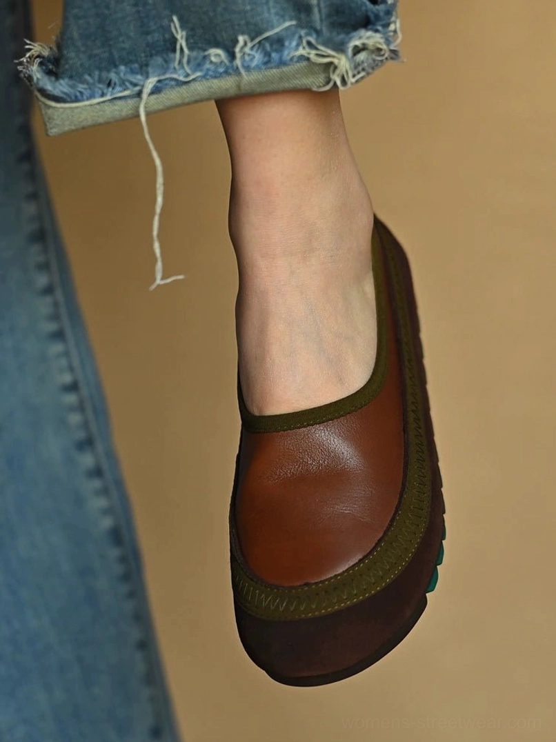 Front view of a brown leather slip-on shoe worn with rolled denim, highlighting the olive green collar trim and dark rubber sole