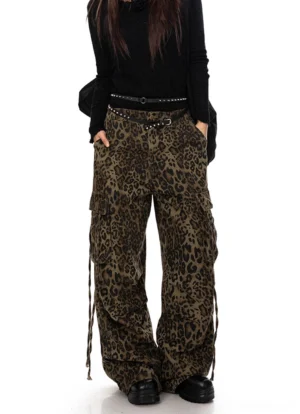 Front full-body view of brown leopard print wide leg cargo pants styled with an all-black streetwear outfit and side cargo-pocket drawstrings