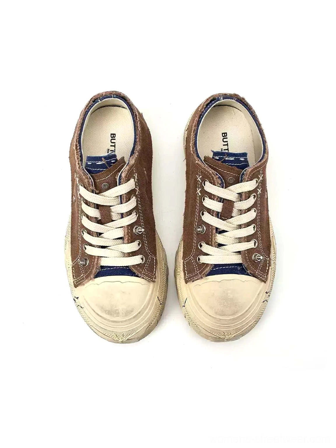 Front view of brown low-top platform sneakers with off-white toe caps and white flat laces