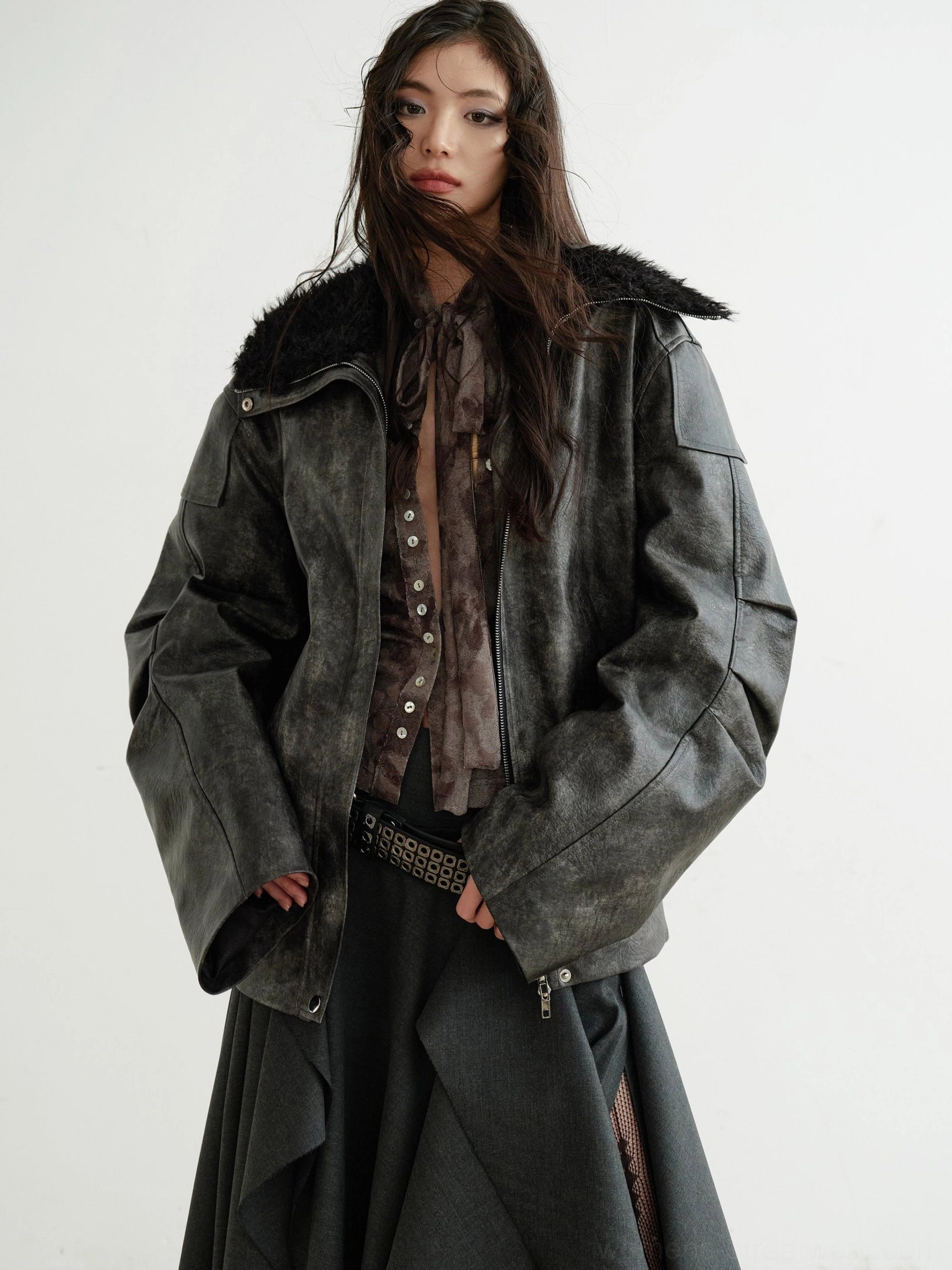 Brown marble print tie-waist shirt layered under fuzzy collar leather jacket