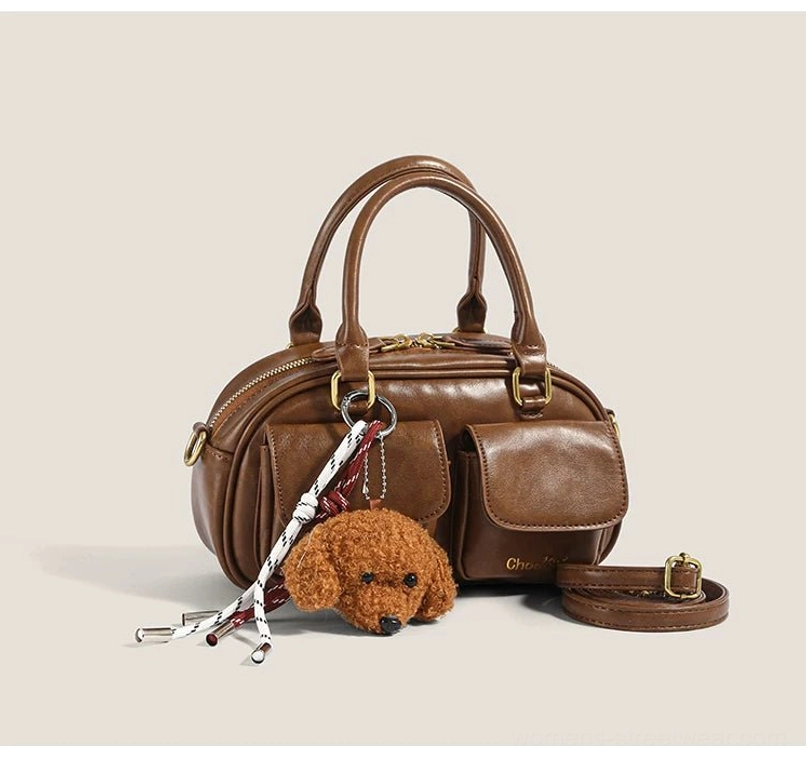 Brown mini bowling crossbody bag with front utility pocket puppy pendant gold zipper and removable long shoulder strap