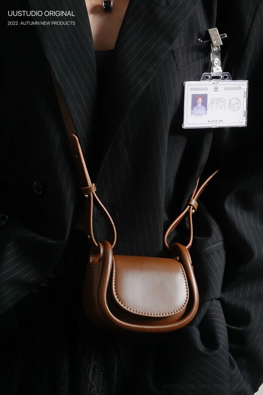 Brown mini saddle crossbody shoulder purse paired with a black suit and workwear-inspired outfit