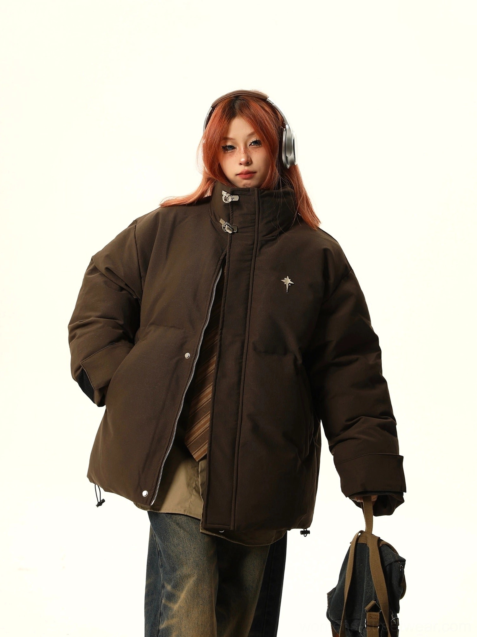 Brown oversized stand collar puffer jacket styled with striped tie and canvas crossbody bag
