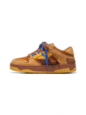 Brown perforated dual-lace platform sneaker with tan suede upper, blue flat laces, yellow mesh panels, and chunky rubber outsole