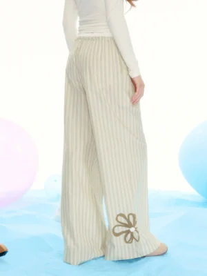 Back close-up of brown pinstriped palazzo pants with elastic waistband and small bow embroidery near the hem