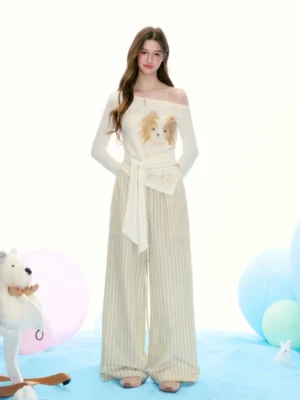 Brown pinstriped wide-leg palazzo pants styled with an off-shoulder knit top in a pastel streetwear studio
