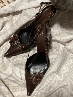 Brown pointed slingback heels shown in three-quarter side view with layered crystal flower studs, slim ankle strap, black insole, and stiletto-style heel