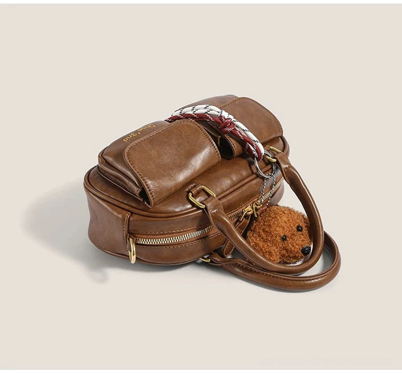 Top angled view of brown PU faux leather puppy charm bowling handbag with double handles ribbon detail and gold hardware