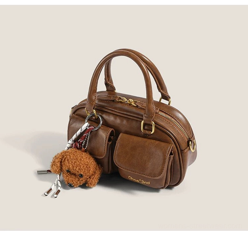 Brown PU faux leather puppy charm mini bowling bag with top zipper double handles and ribbon pendant side view