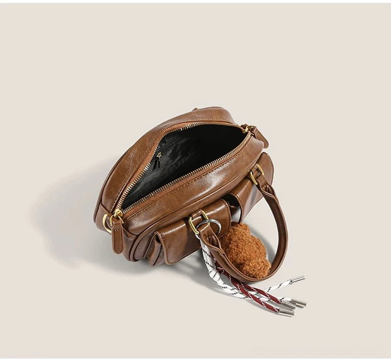 Open brown puppy charm pocket bowling bag showing zippered main compartment interior strap hardware and organized storage