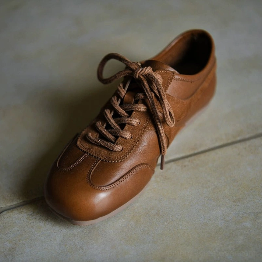 Brown retro leather sneakers in three-quarter flat lay view with rounded square toe, mixed suede and leather panels, brown laces, and low outsole