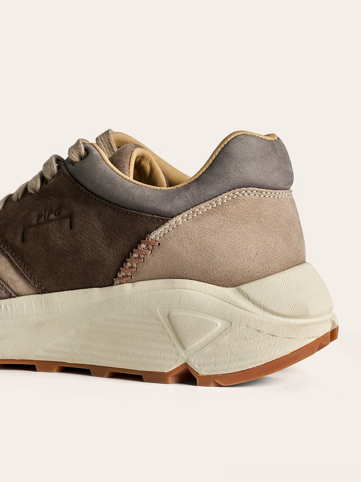 Side profile of brown retro trail runner sneaker with sculpted off white midsole and suede overlay construction
