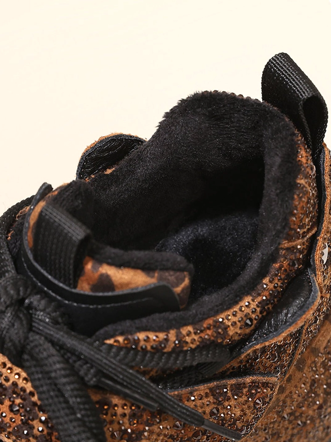 Close-up of fuzzy warm lining inside brown rhinestone leopard platform sneaker with heel pull tab