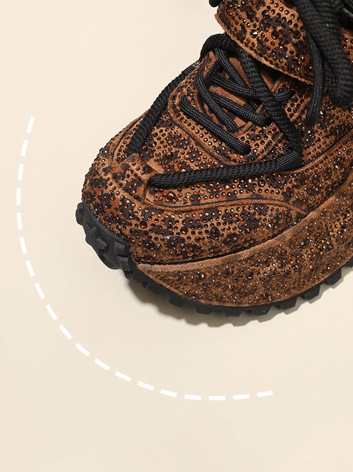 Close-up of sparkling rhinestone leopard toe box and thick textured platform outsole on brown sneakers