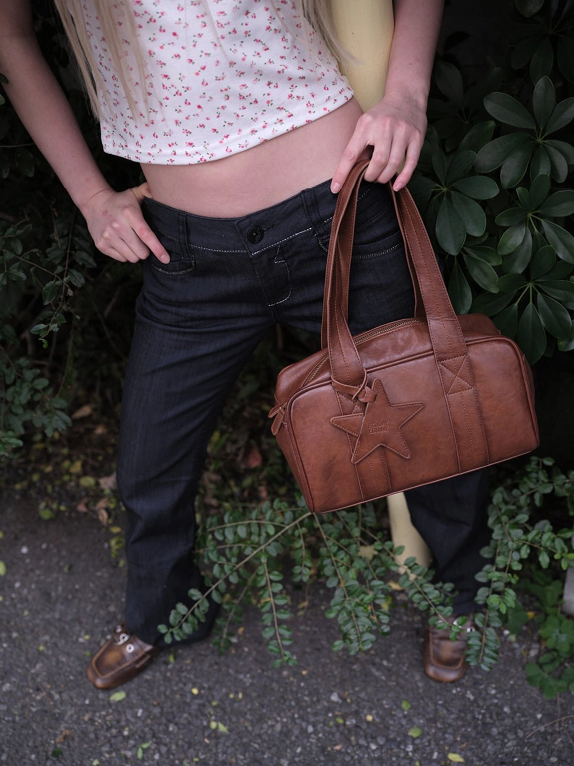 Brown square toe ruched buckle flats worn with low-rise dark jeans and brown star leather tote