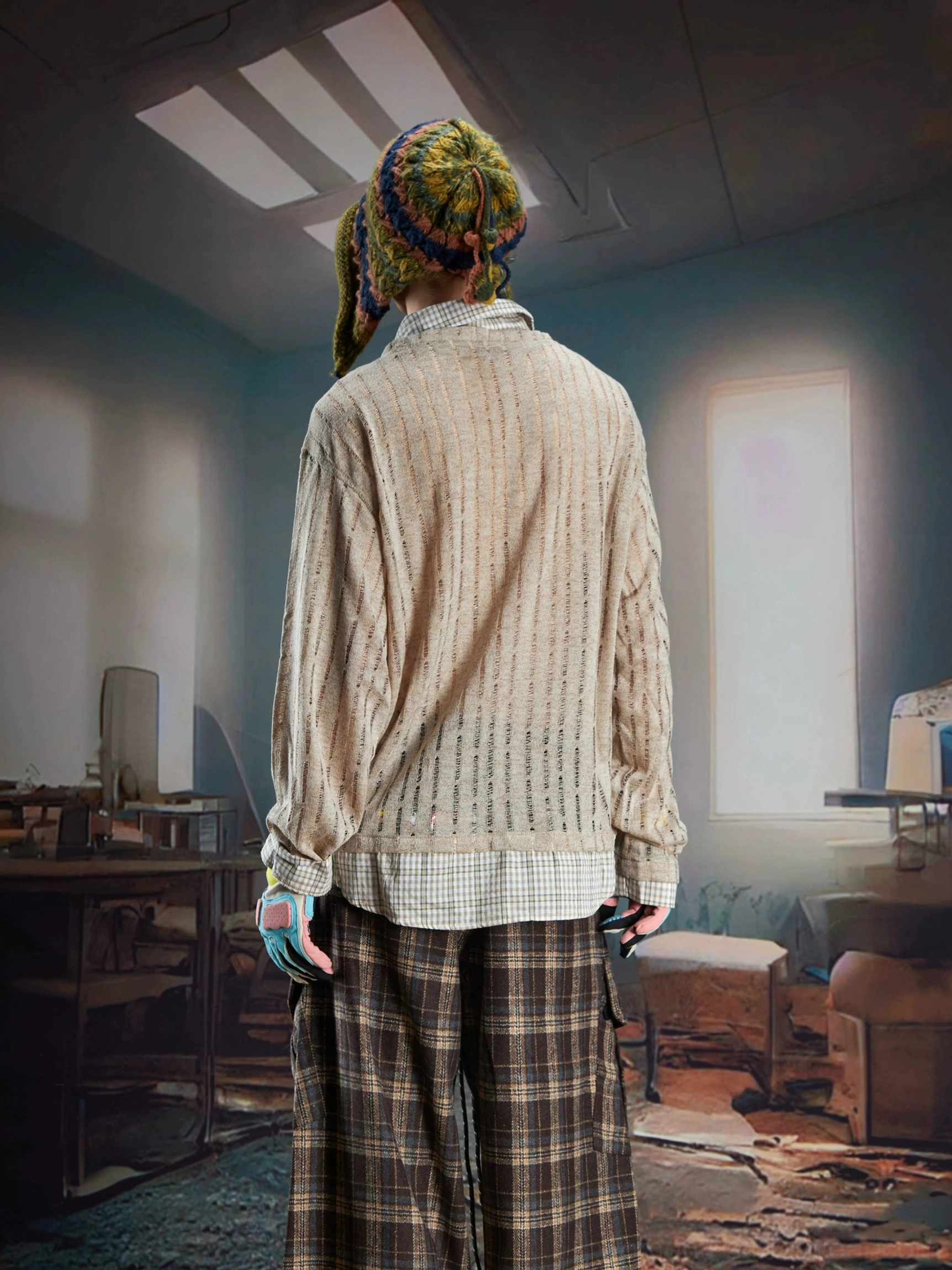 Back view of a male model wearing a brown sheer layered vintage print shirt sweater with textured ribbing and plaid shirt hem detail