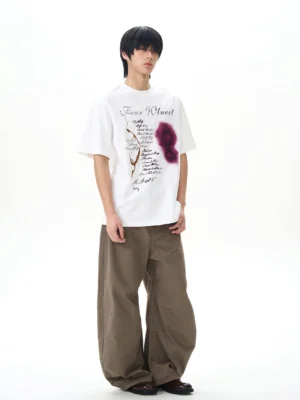 Brown baggy skater denim pants styled with a graphic white tee in a relaxed full front streetwear outfit