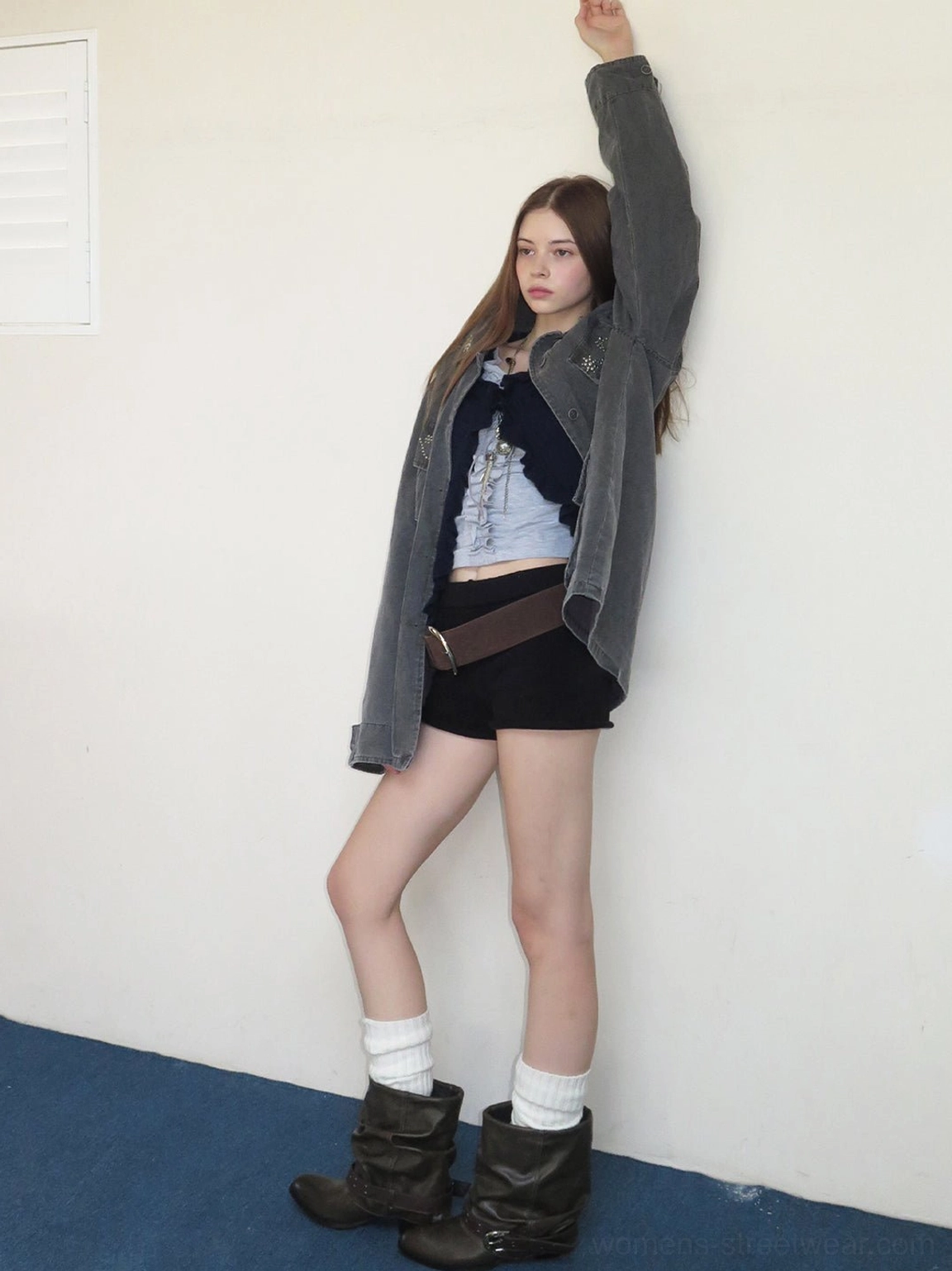 Side view of brown slouchy western buckle ankle boots paired with a denim jacket and casual layered streetwear