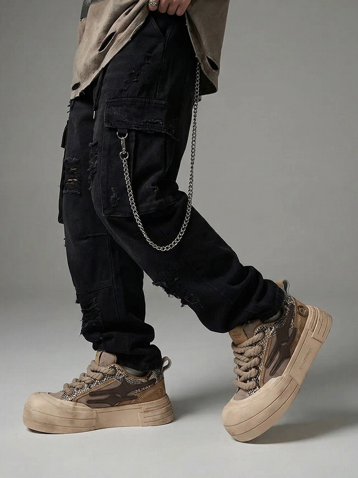 Brown smiley lightning platform sneakers styled with black ripped cargo pants and chain accessory for streetwear outfit