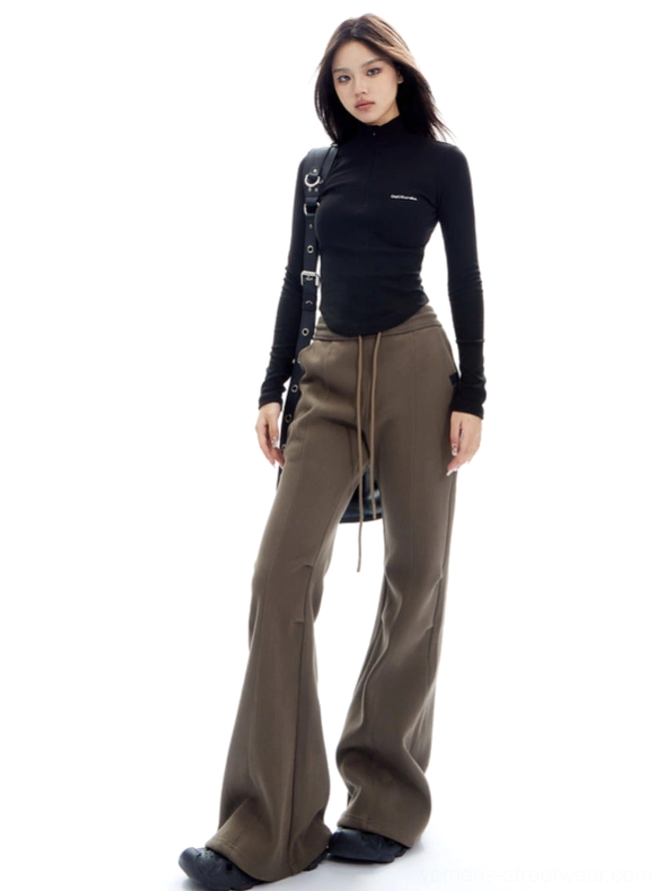 Low-angle view of soft textured brown knit-style flared pants with a relaxed wide-leg streetwear fit