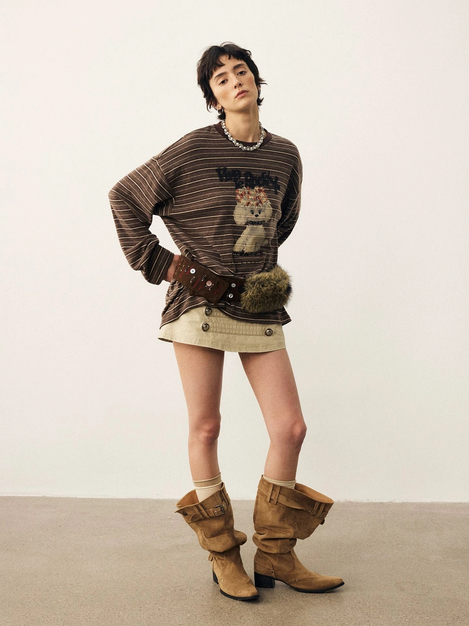 Brown striped puppy graphic oversized long sleeve t-shirt styled with beige mini skirt and western boots front view