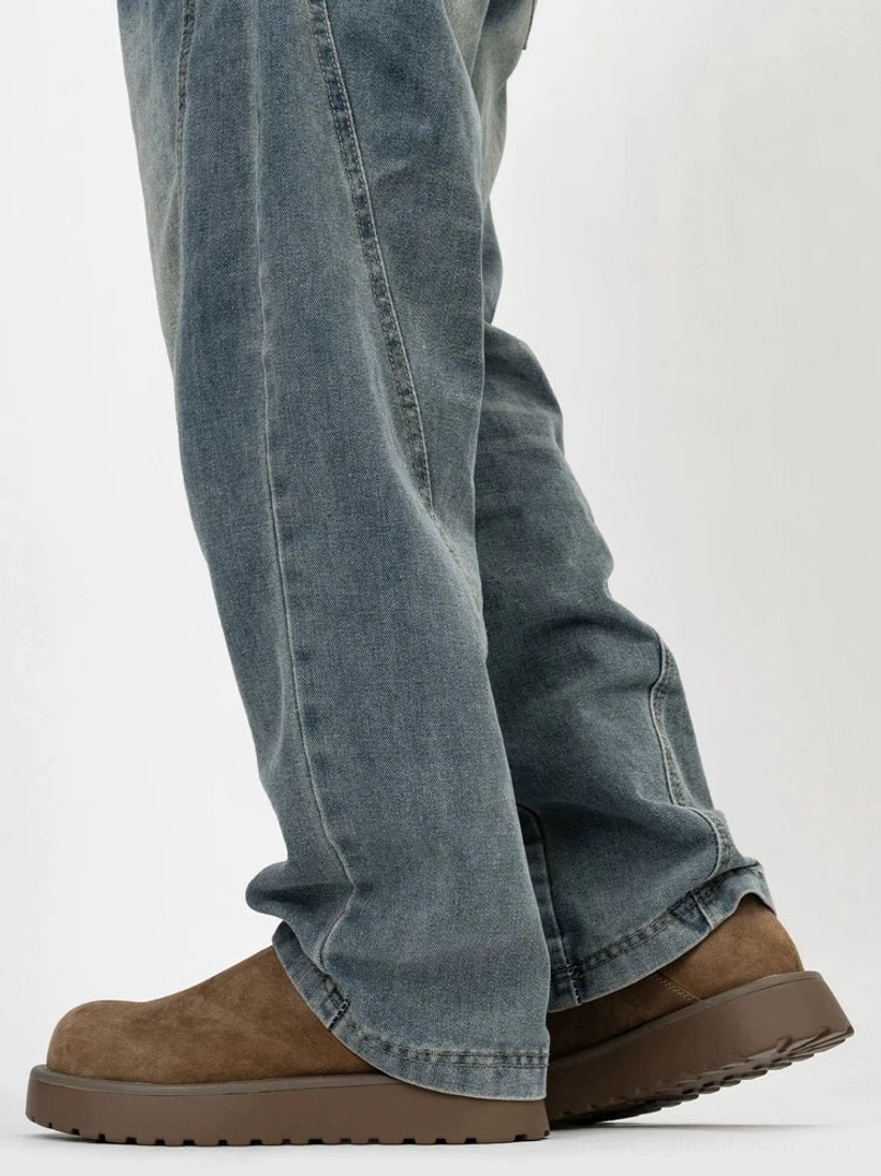 Rear side view of brown suede-look platform slip-on clogs worn with loose blue denim jeans