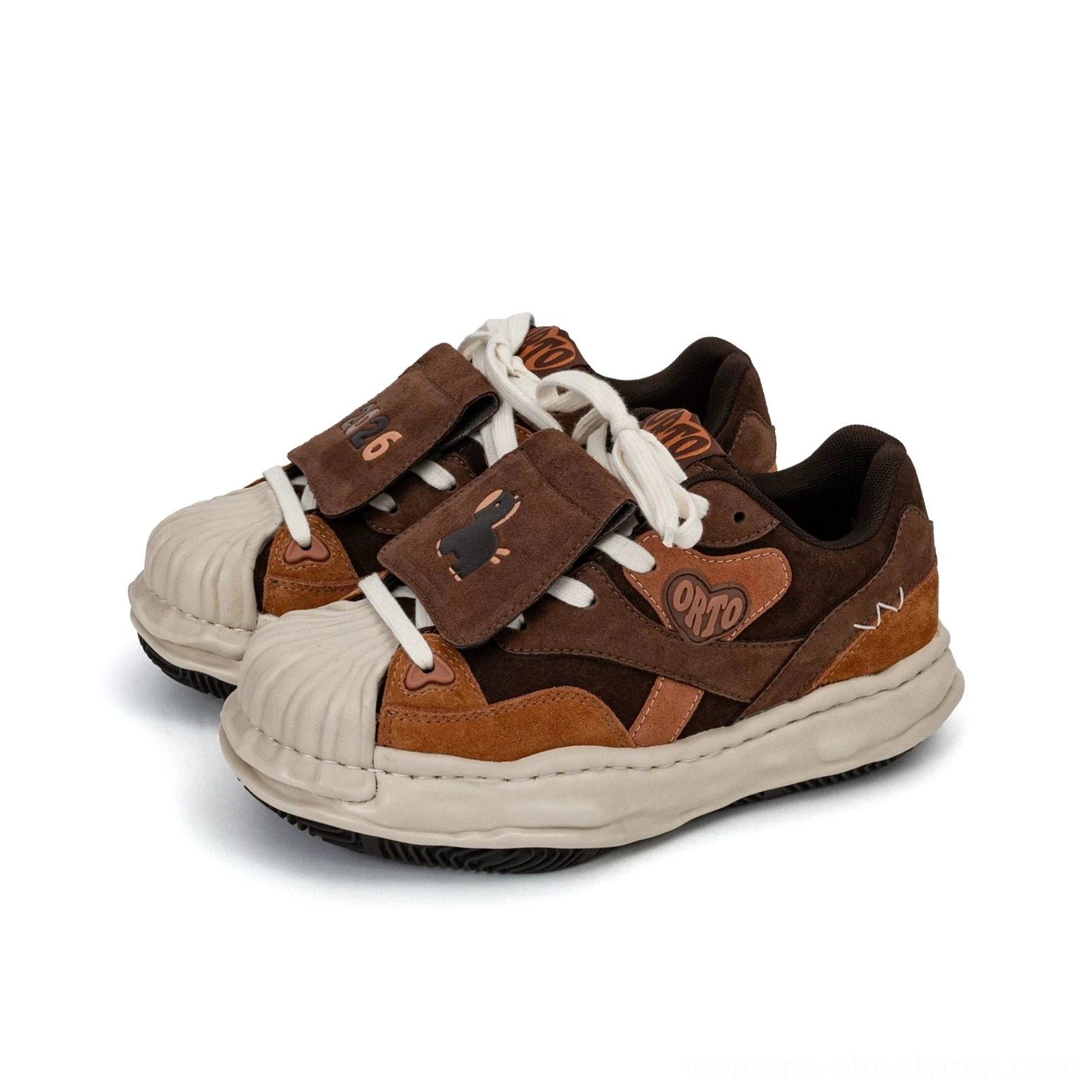 Brown and tan patch low top sneakers with dog embroidery, dark suede-style panels, shell toe, and thick cream rubber lift sole