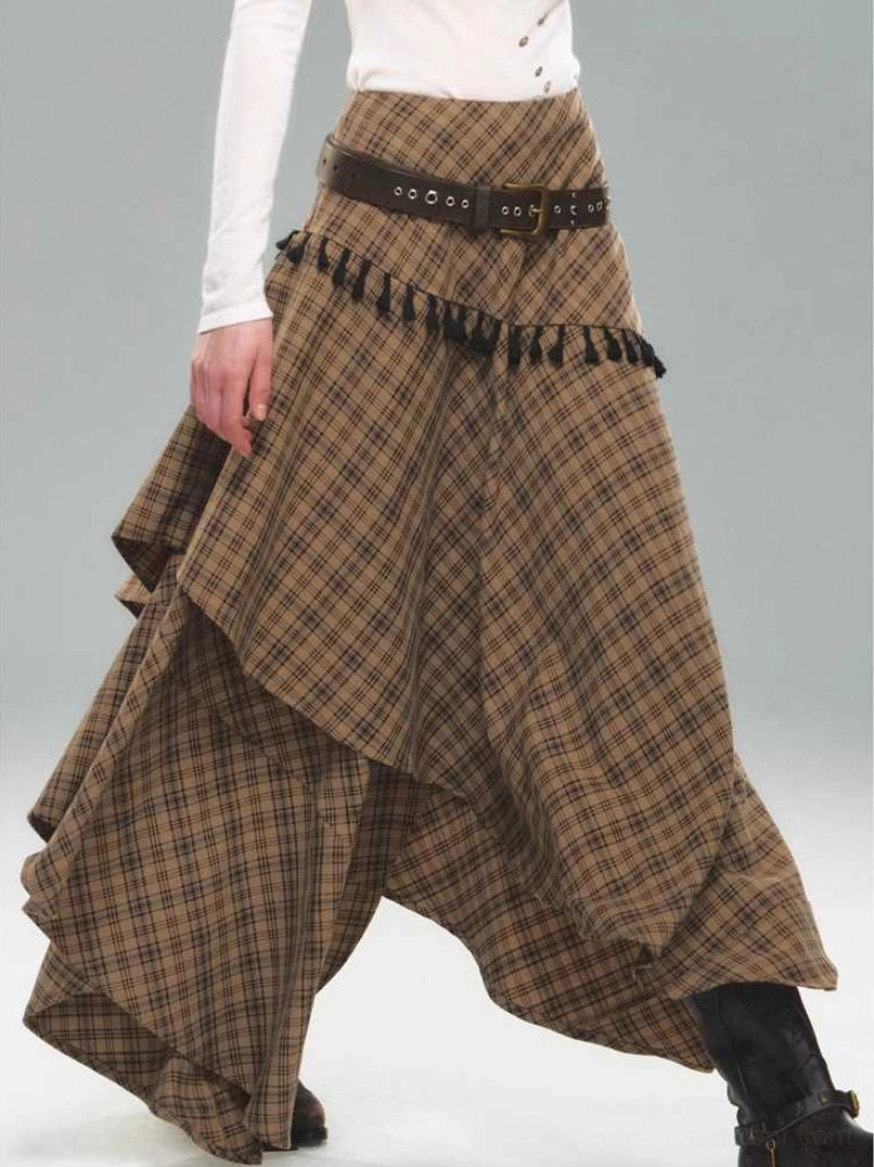 Side view of brown tartan plaid tassel skirt with irregular layered hem, black decorative tassels, and contemporary alternative fashion styling
