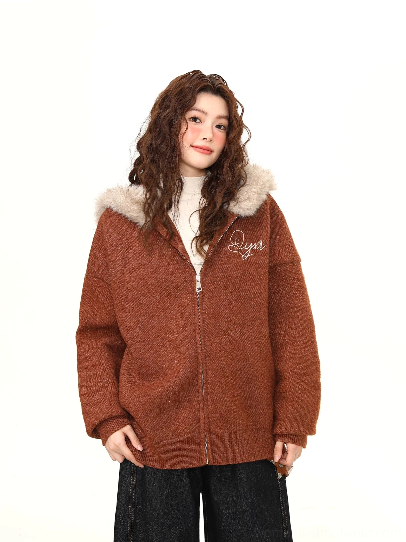Half-body view of a brown textured knit-style jacket with faux-fur hood trim, front zipper, and delicate chest lettering