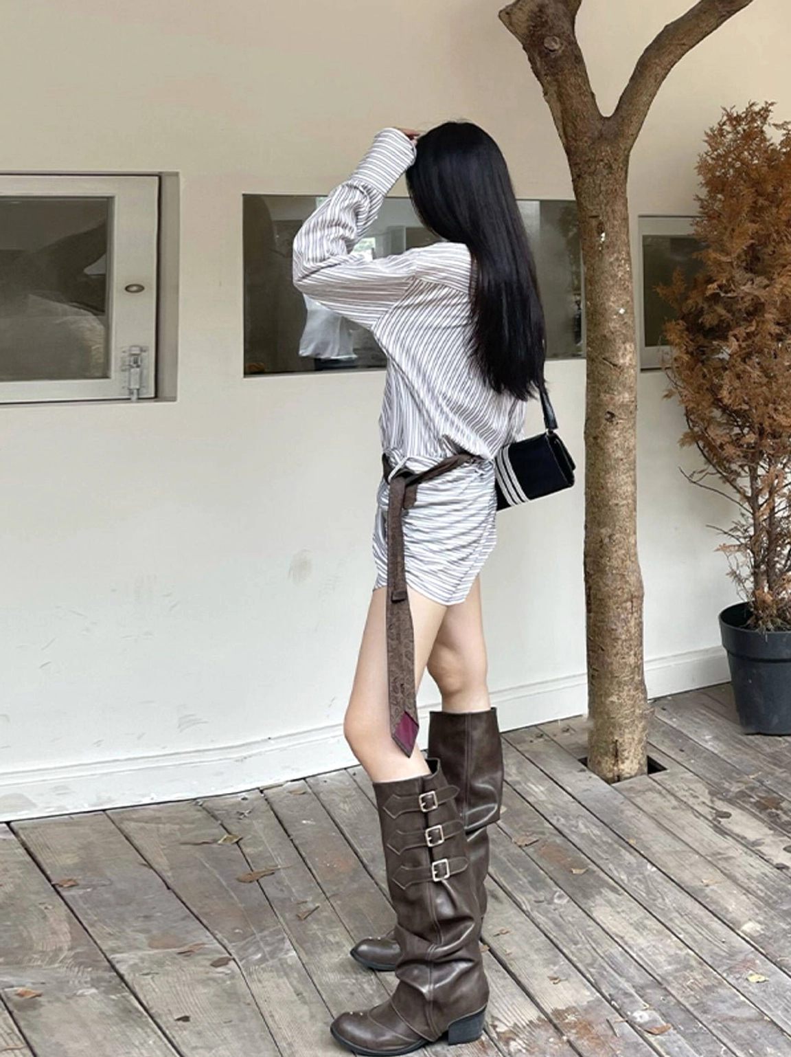 Brown western knee-high boots shown from the rear with ruched shaft, triple buckles, pointed toe, and low block heel