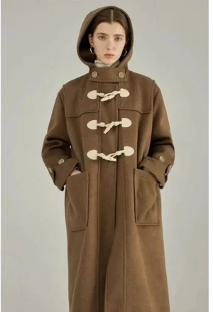 Brown wool duffle coat with horn toggle closures front view model wearing coat with hands in pockets