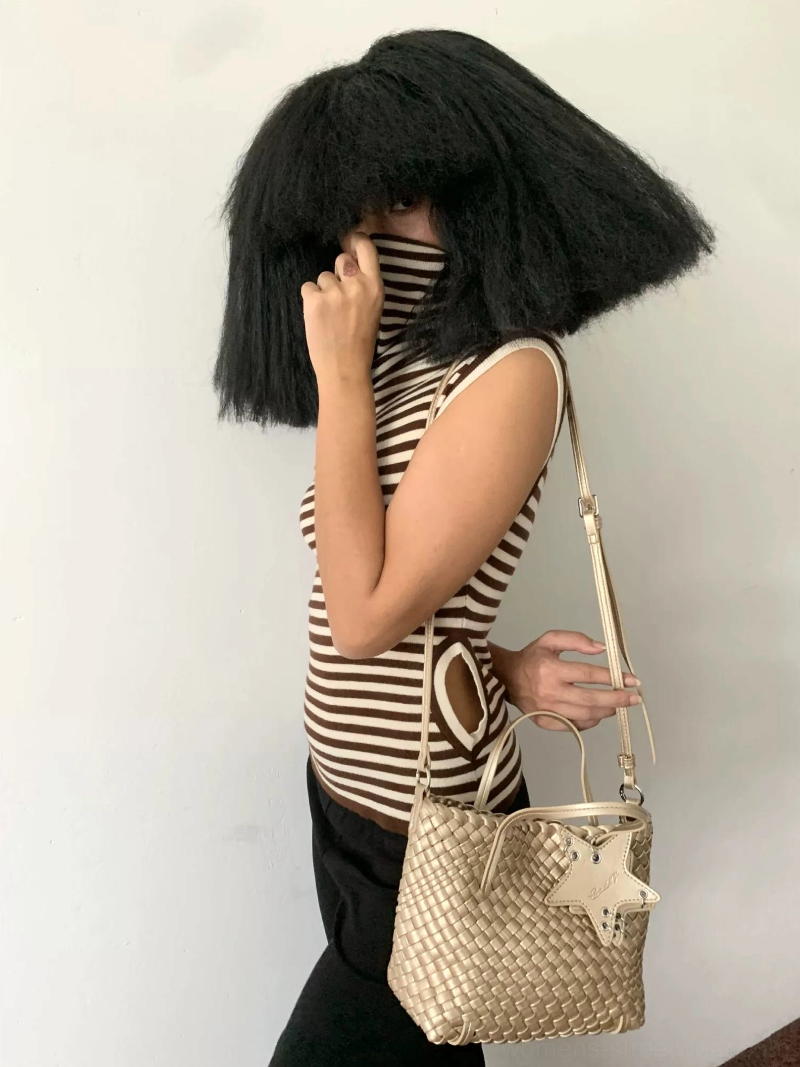 Brown woven star charm shoulder bag worn crossbody with striped tank top streetwear styling