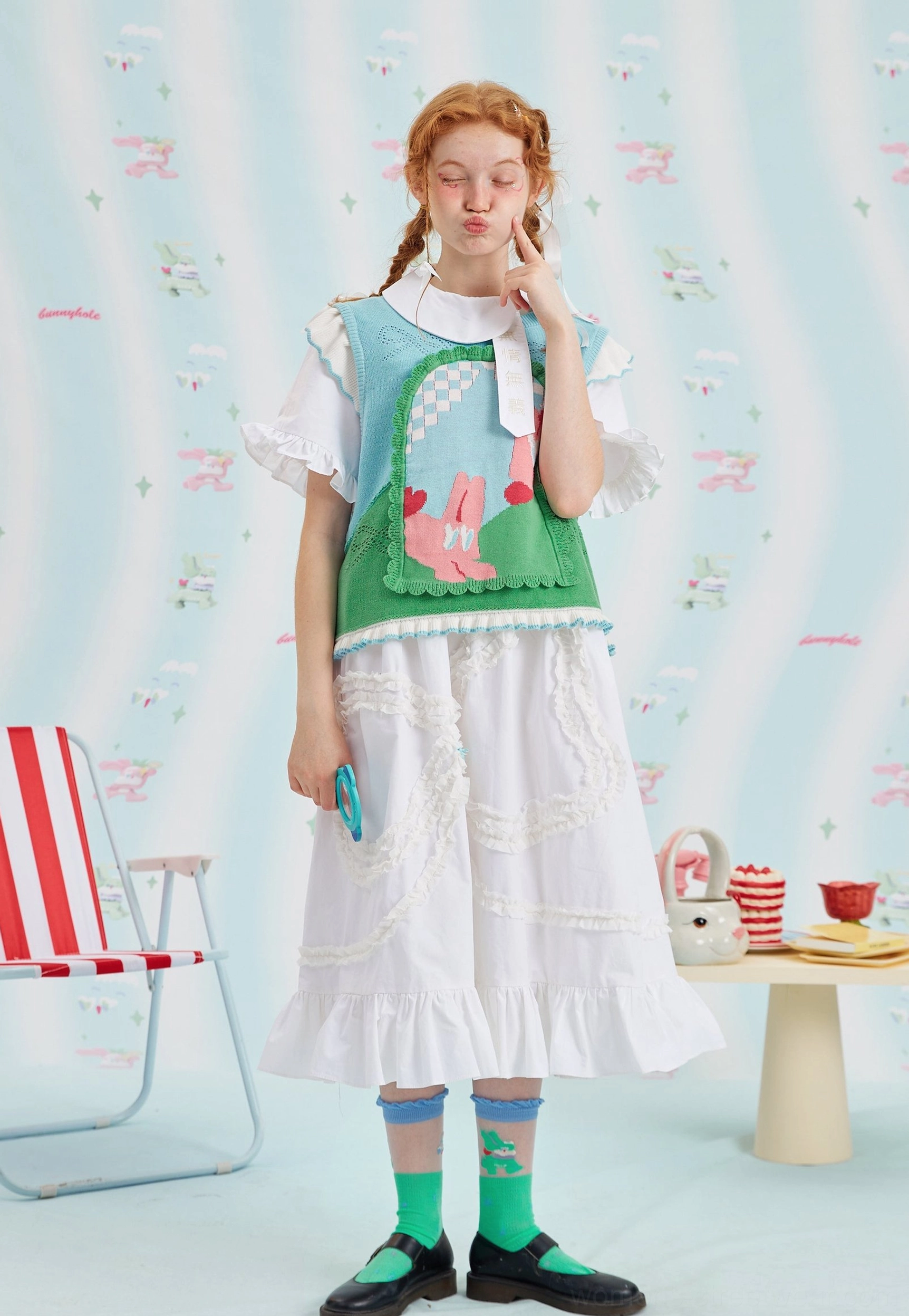 Bunny jacquard knit sweater vest layered over a white ruffled blouse and styled with a feminine midi skirt