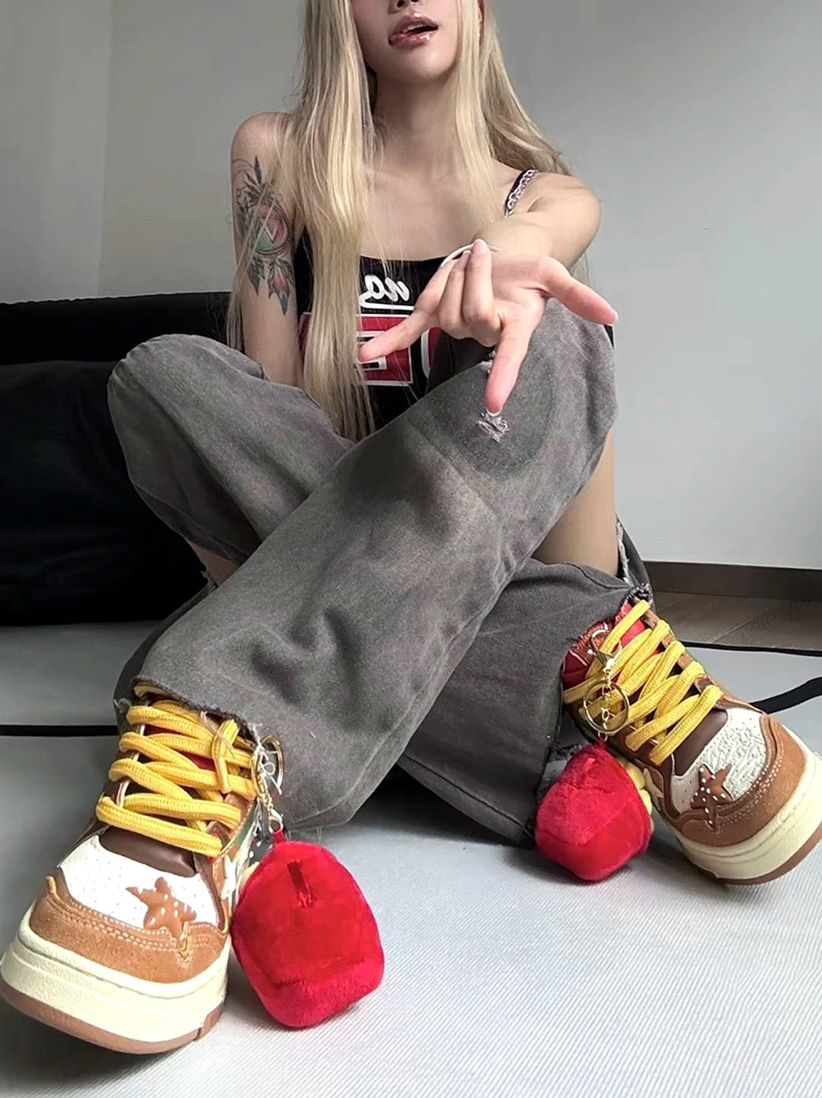 Burger Star low-top skate sneakers worn in a seated casual outfit showing brown panels and red sauce-packet-inspired heel details