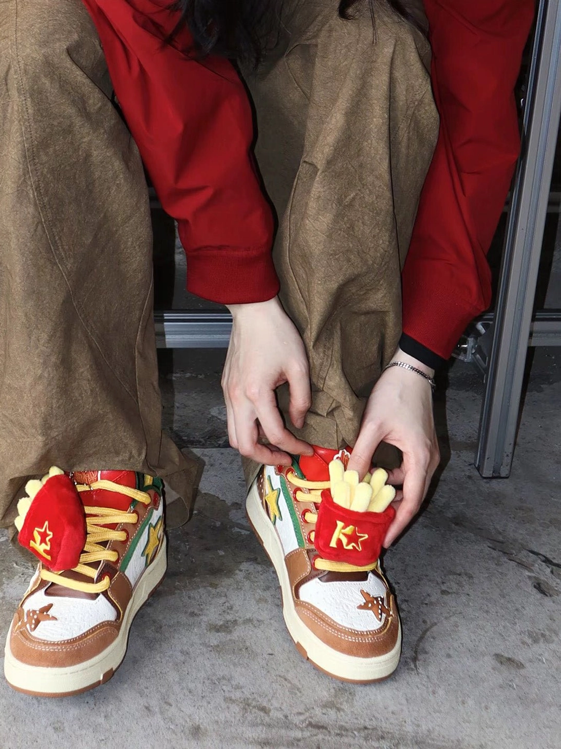 Burger Star low-top skate sneakers in a casual streetwear outfit with model adjusting yellow shoelaces and fast-food accents