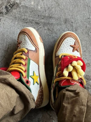 Top view of Burger Star low-top skate sneakers worn with brown cargo pants showing yellow laces and fries-inspired tongue charm