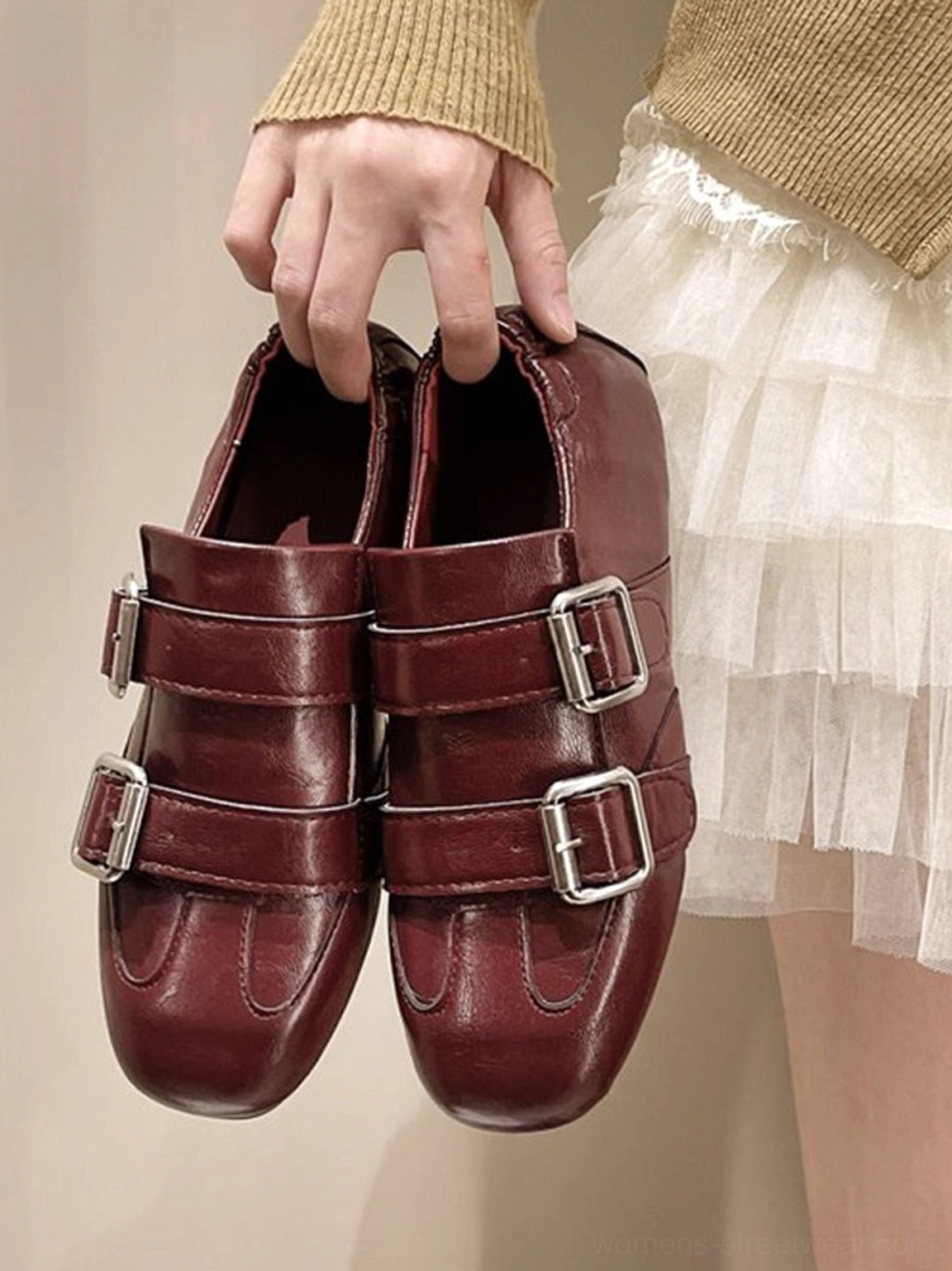 Burgundy double-buckle leather loafers with silver hardware styled with knitwear and tulle skirt