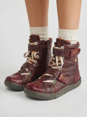 Burgundy fleece-lined mid-calf boots worn with cream ribbed socks, orange fleece lining, straps, and lace-up closure
