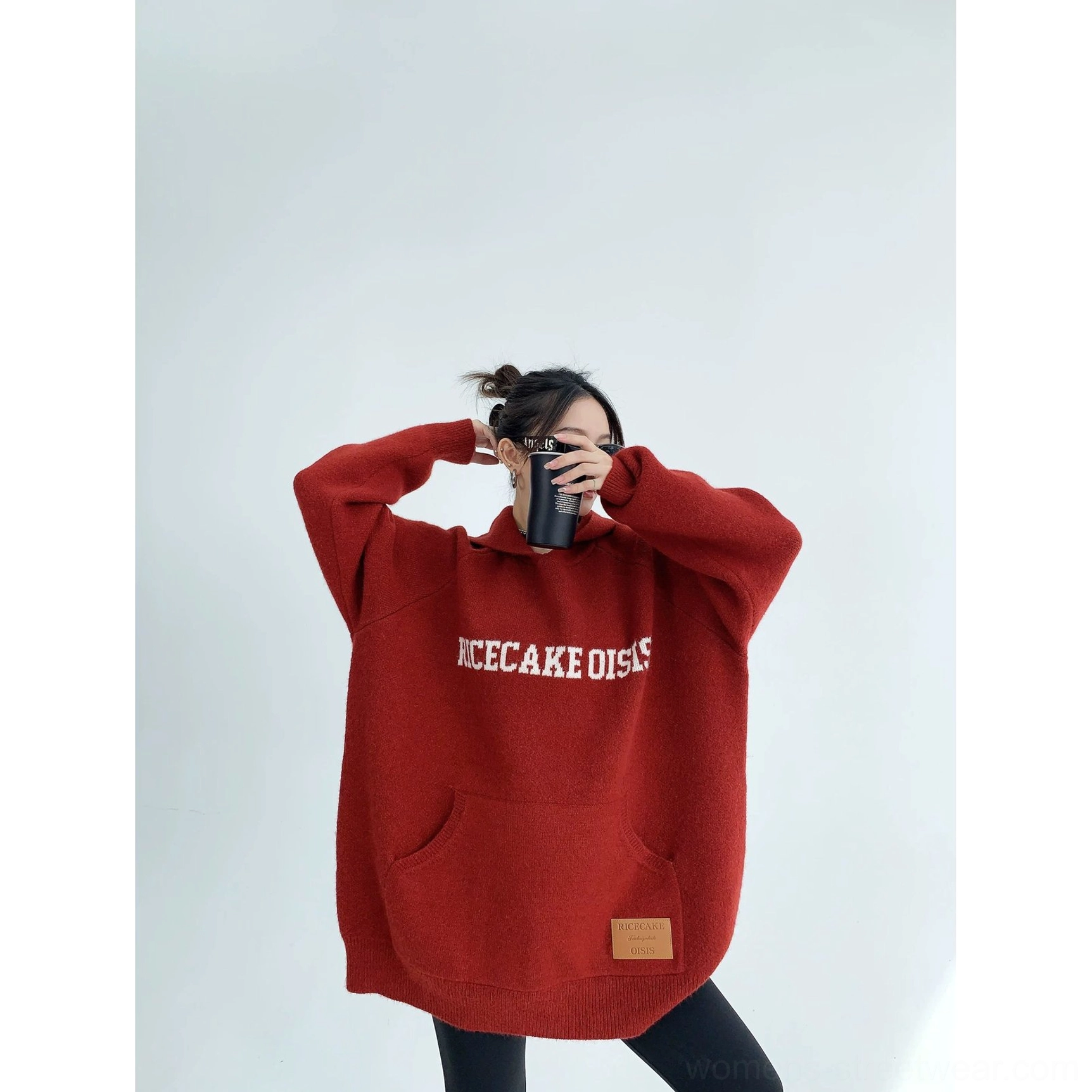 Back view of a burgundy oversized knit hoodie showing the relaxed silhouette, ribbed hem, long sleeves, and cozy fit