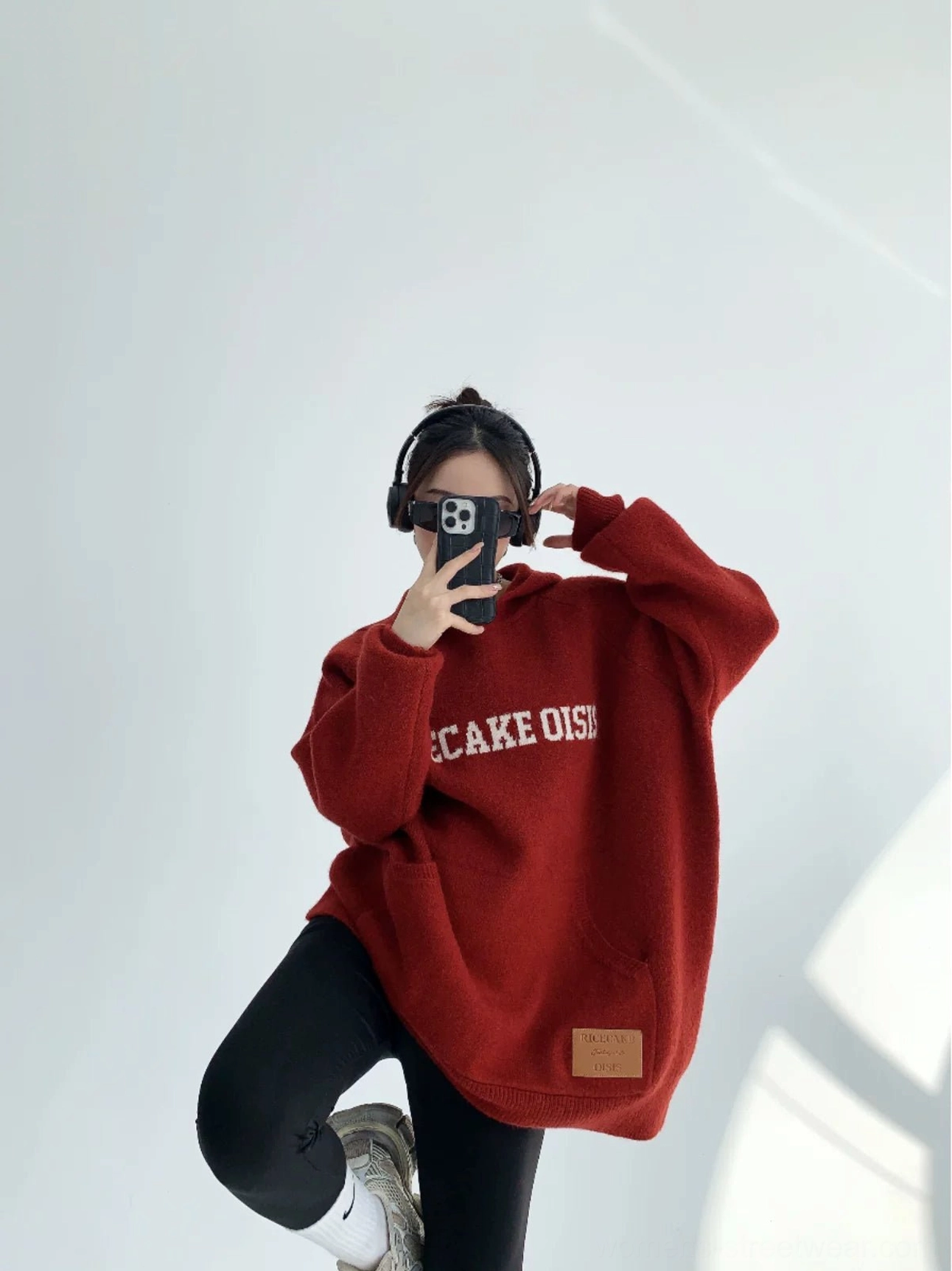 Burgundy oversized knit hoodie with front lettering, ribbed cuffs, kangaroo pocket, and faux-leather hem patch