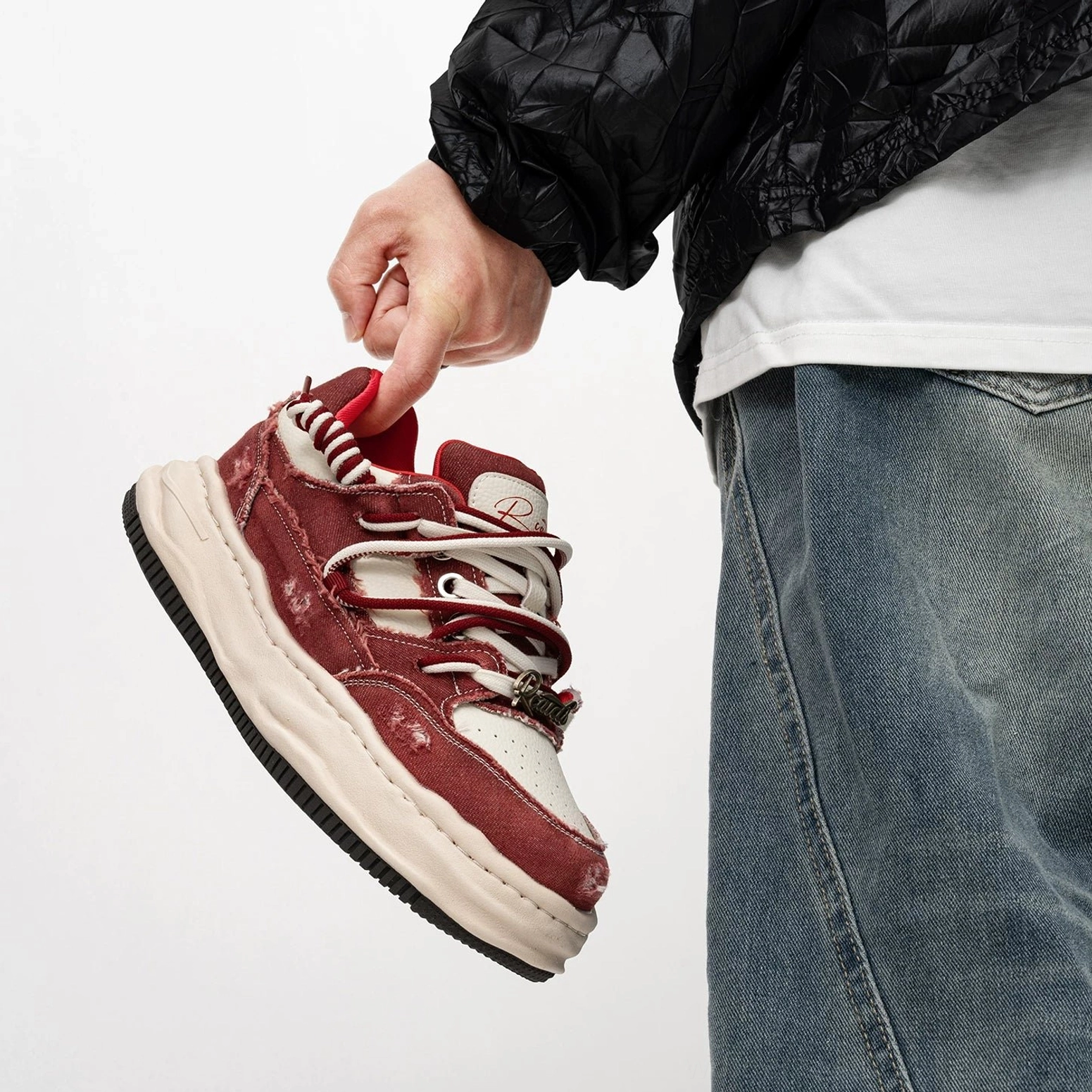 Burgundy red and off white distressed casual platform sneakers with branded tongue detail and layered streetwear styling