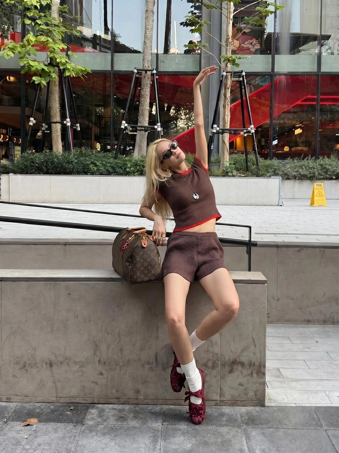 Burgundy ribbon lace-up ballet flats styled with white socks, cropped top, and shorts for casual streetwear