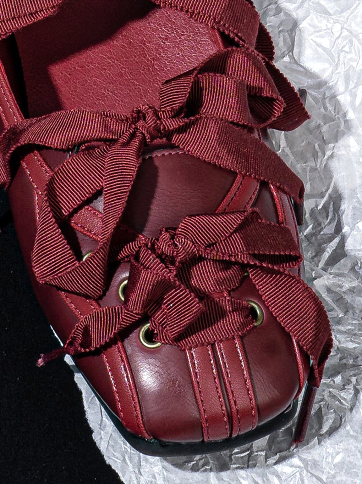 Front close-up of burgundy ribbon lace-up ballet flats with bow lacing and square toe detail