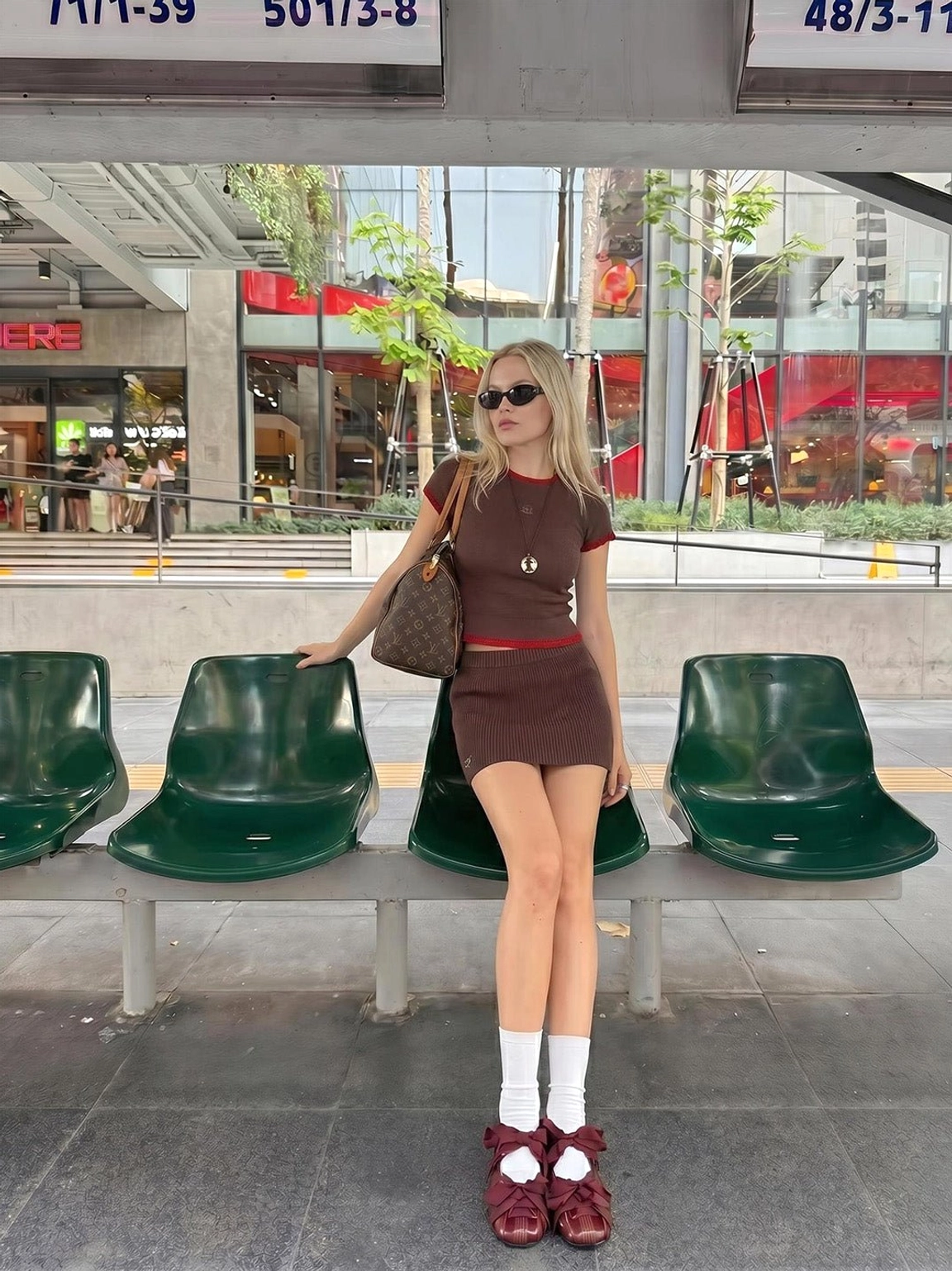 Burgundy ribbon lace-up ballet flats worn with white socks and a brown mini dress in preppy streetwear styling