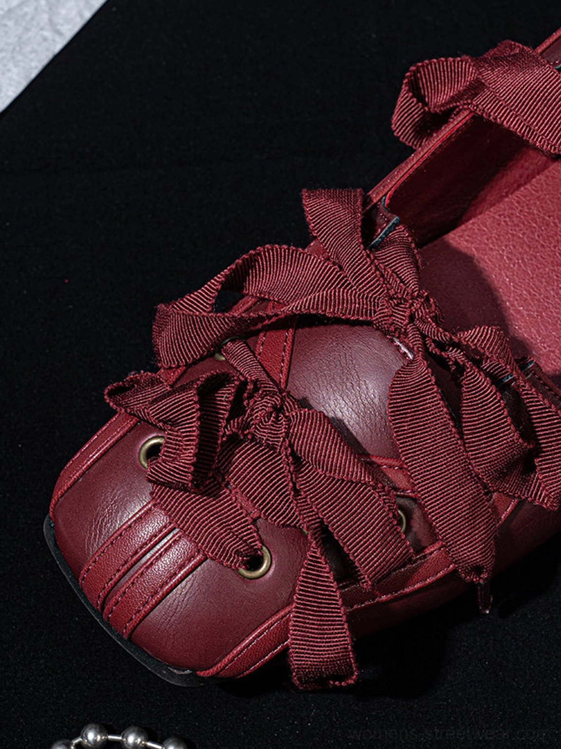 Top view of burgundy ribbon lace-up ballet flats showing bow laces, metal eyelets, and square toe caps