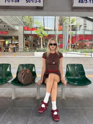 Woman styling burgundy ribbon lace-up ballet flats with white socks and a retro brown streetwear set