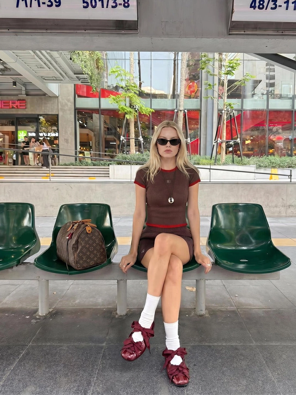 Woman styling burgundy ribbon lace-up ballet flats with white socks and a retro brown streetwear set
